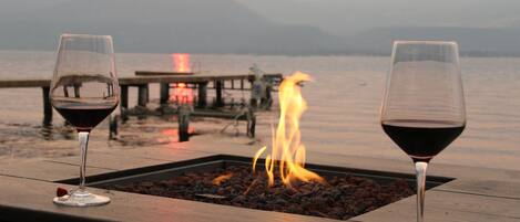 Lakefront concrete block patio with firepit and muskoka chairs !