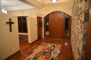 Beautiful open entryway with rock wall and high ceilings.