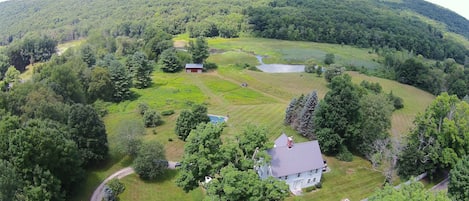 Copter view house, pool, barn, pond and ridge. 