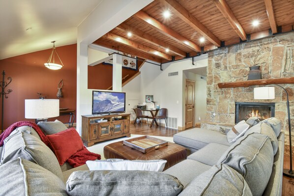 Living room w/ view of fireplace, desk and 52" TV