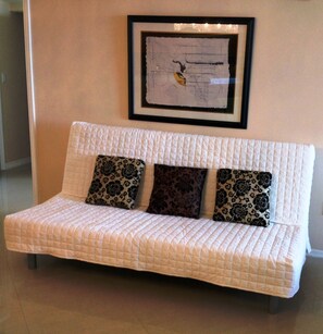 Futon in the living room sleeps 2 temporary staying in the condo as a guests