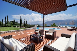 Shaded pergola next to the pool with seating area