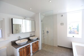 Large bathroom with walk-in shower, his n hers sinks, and bath
