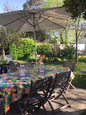 Grande table de jardin, avec deux parasols