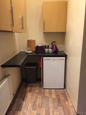 Kitchen equipped with job oven microwave kettle and cooking utensils