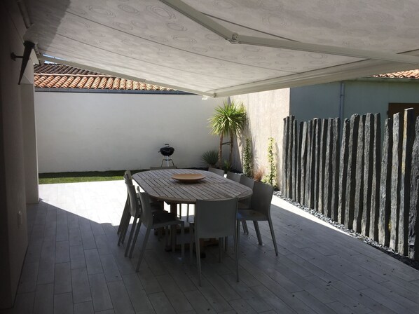 la superbe terrasse offre un coin repas, un coin transats et barbecue 