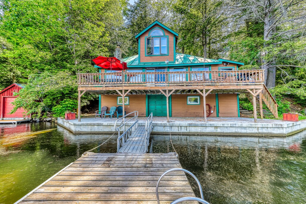 A Vermont lake home rental sits on the water with a long dock in front