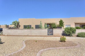 Back of the house with walled backyard and large landscaped common area