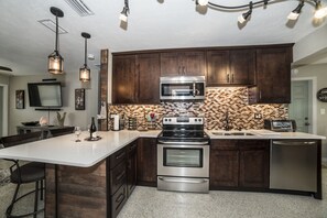 Stainless steel kitchen equipped with many baking and cooking  supplies