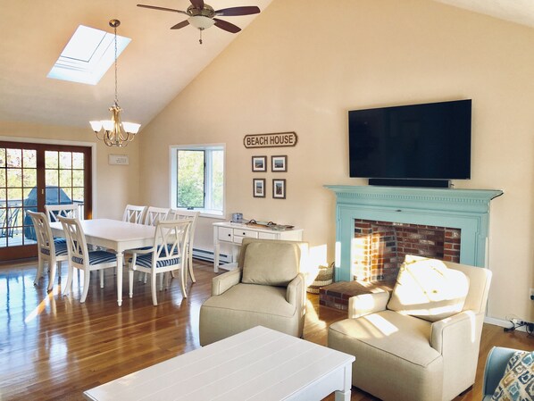 Sun drenched open concept living and dining room with cathedral ceilings