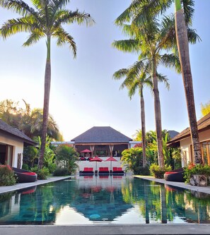 The pool is expansive, with a sleek design stretches across lush garden.
