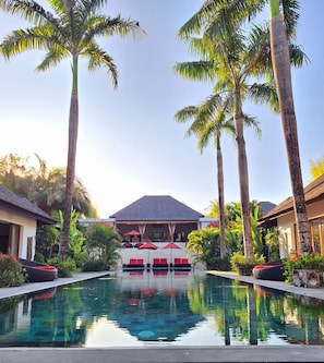 The pool is expansive, with a sleek design stretches across lush garden.