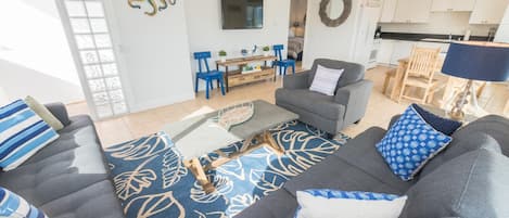 Drop your bags and enjoy a carefree, car-free vacation in this bright and cheery upstairs beach house, just one home from the sand!