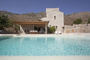 Pool, villa and mountain behind it
