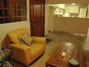 Living Room with flat panel TV and a two sitter couch. Door leads to large patio