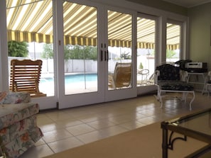 Sunroom with wet bar looks out into the pool area.