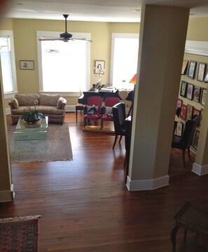 living room, surrounded by windows, baby grand, Murphy bed behind music wall