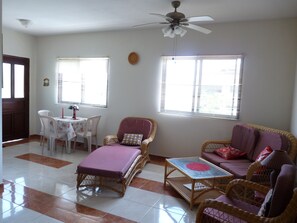 Ceramic tiled specious Living room with three large windows - different angle.