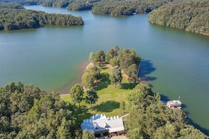 View from above showing front lawn lake house and dock