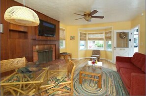 Airy and cheerful, the living/dining area features a bay window,fireplace,andTV