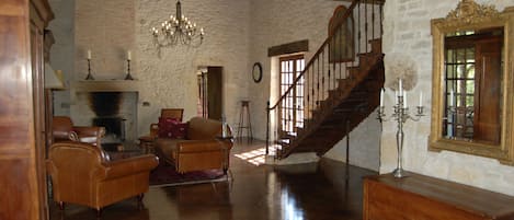 Living room with leather club furniture and 2 stone fireplaces