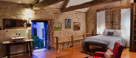 Master bedroom with open floor plan and ancient beams