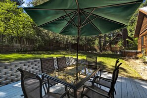 Backyard patio with outdoor dining table and umbrella.