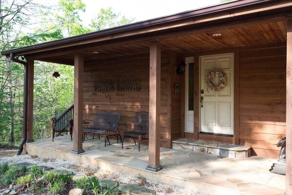 On the covered front porch is a metal glider and chair.