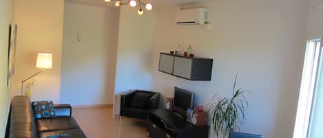 Living room with leather couch, flat screen tv. 
