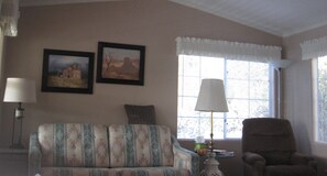 Living room with comfortable seating and many windows plus hide-a-bed