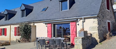 Terrasse avec salon de jardin et store.