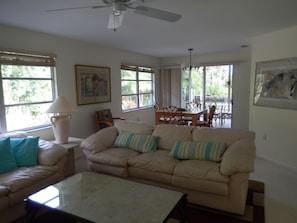 Living room with leather couch and love seat. Great light.