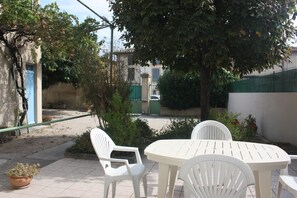 La terrasse vue de la cuisine. Au fond, le portail d'entrée.