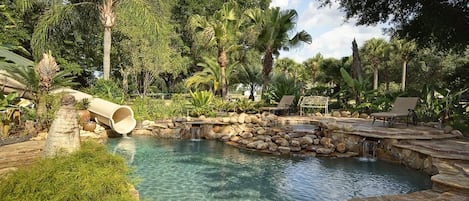 a 2 story enclosed water speed slide leads into the tropical, waterfall-fed pool