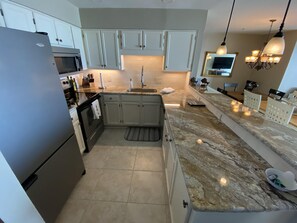 Granite kitchen, under cabinet lights, large stainless sink, stone backsplash 