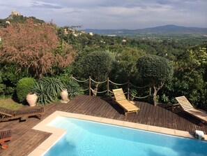 Large pool surrounded by decking and sunbeds. 