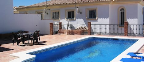 Private heated pool set in the back garden patio area