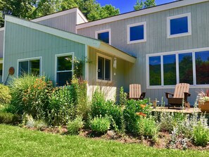 Front of house with full gardens and front deck