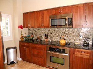 Second view of kitchen highlighting modern backsplash.