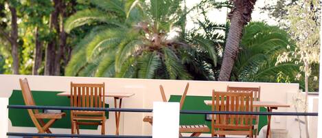 Terrace in front of Magnolia Garden with view to palm garden over the street.