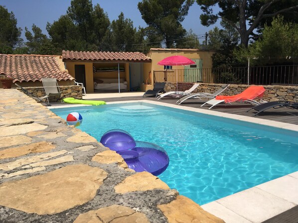 la piscine 7X4 avec à l'arrière son coin à l'ombre, douche et canapé