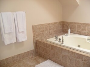 A spacious master bathroom with a separate shower