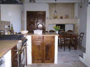 kitchen - Viking stove, table, fireplace. Marble countertops.