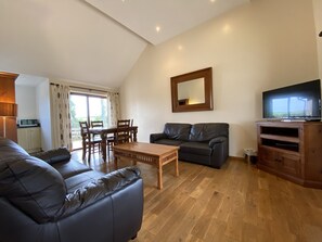 Spacious lounge with real oak floors and large TV