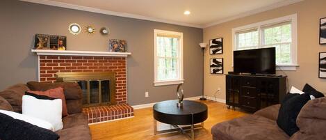 Living room area gleaming with natural light, flat screen tv 