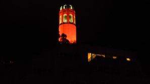 STREET VIEW OF CONDO LIGHTS WITH COIT TOWER ABOVE.