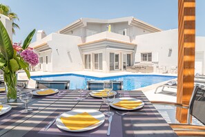 Dining area in the outdoor space overlooking the pool.