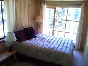 Upstairs bedroom with queen bed and partial lake view