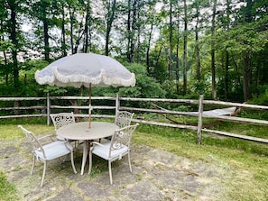 Outdoor dining table by the pool and hammock by the stream