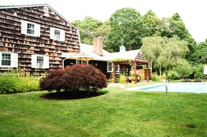 Huge backyard drowning in flowers, with a pool close to the house